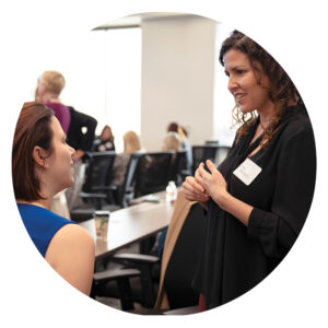 two women talking to each other in a large event space