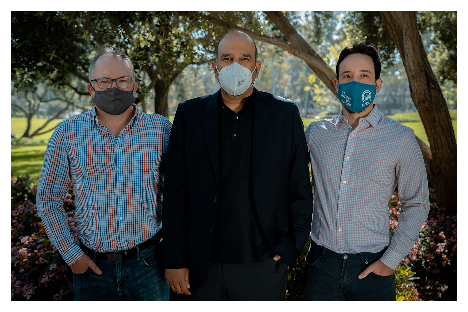Three men in masks standing outside
